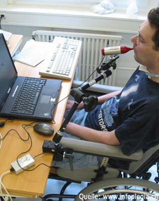 Auf dem Bild ist ein Tetraplegiker abgebildet, der mit einer Mundmaus arbeitet.