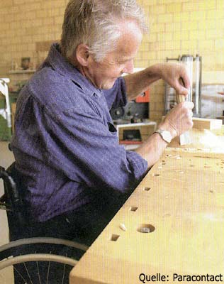 Auf dem Bild ist zu sehen, wie ein Rollstuhlfahrer Schreinerarbeiten ausfhrt.