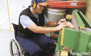 Ein junger Querschnittgelähmter  Mann arbeitet an einer Bandschleifmaschine.